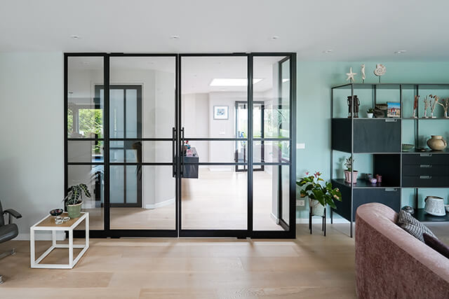 Dubbele taatsdeur met zijpanelen van Aluwdoors in een woonkamer