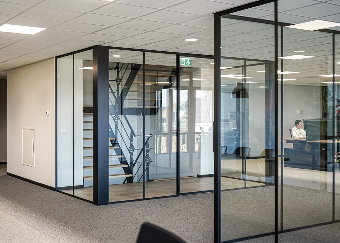 Veilig en stijlvol glazen scheidingswand met stalen frame, ideaal voor kantoorinterieurs en vergaderruimtes.