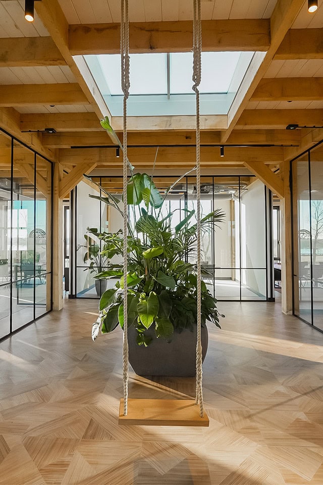 High-quality custom-made steel door and wall in modern interior, natural wooden frame, glass walls and green plants, stylish and functional room design.