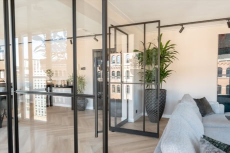 Elegante stalen afscheidingsdeur met glazen panelen voor een moderne en industriële uitstraling.