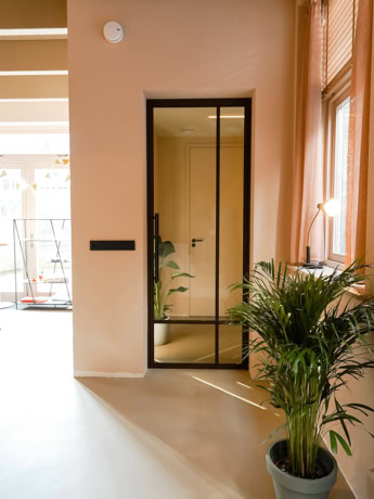 Moderne stalen deur met glazen panelen op maat voor een stijlvolle interieurafwerking.