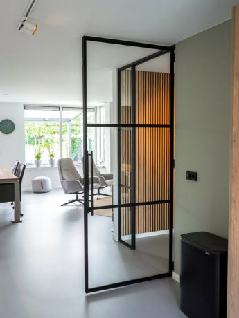 Modern steel dividing door with black frame and wooden panel for a sleek interior finish.