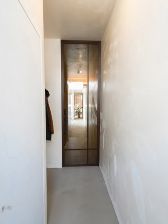 Steel door with glass panel in a modern home, perfectly tailored for a sleek and industrial look.