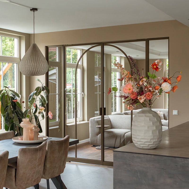 Hoge kwaliteit stalen schuifdeuren met op maat gemaakte wanden in een moderne woonkamer.