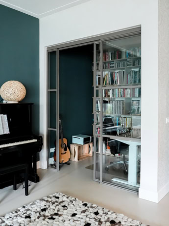 Luxe stalen glazen wandscherm en deur op maat voor een moderne woning, afgewerkt met hoogwaardige materialen voor een strakke uitstraling.