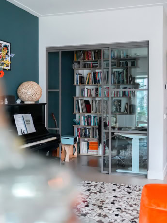 Geschoolde stalen schuifdeuren met glazen panelen voor een moderne interieur scheiding.