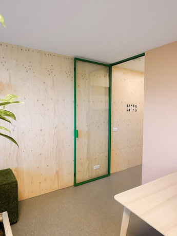 Interior door with steel frame and glass panel, custom-made for modern interiors, in an office or living space.