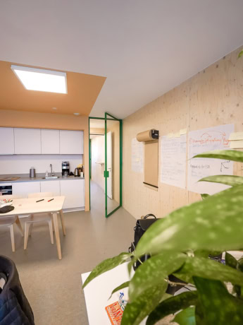 Steel interior door with green trim in a modern office space.