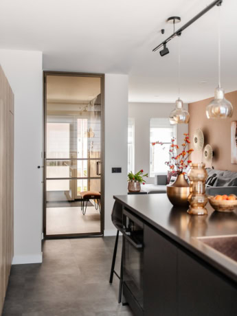 Elegant steel swing door with glass panels for a modern interior door integrated into a luxury living space.