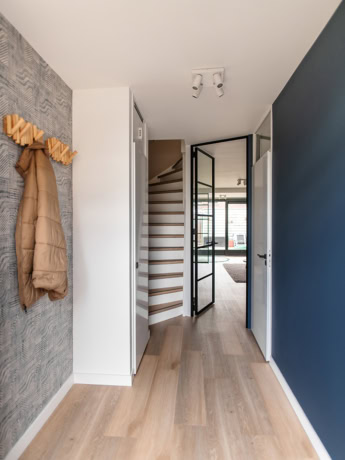 Roughcast steel door with sleek black frame and glasing, modern interior, high quality steel, custom-made door, stylish finish, translucent design.