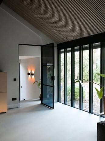 Modern steel sliding door with large glass sections and black frame, perfect for dividing rooms in a contemporary home.