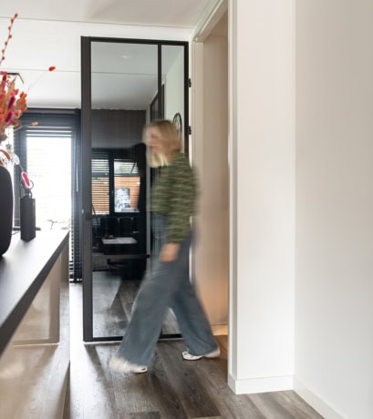 Modern stalen deur op maat met glazen panelen voor een stijlvolle en functionele binnenruimte.