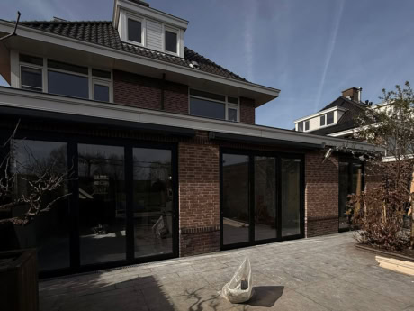 Moderne stalen schuifdeuren op maat voor een strakke uitstraling en optimale lichtinval, perfect voor het creëren van een naadloze overgang tussen binnen en buiten in een woning.