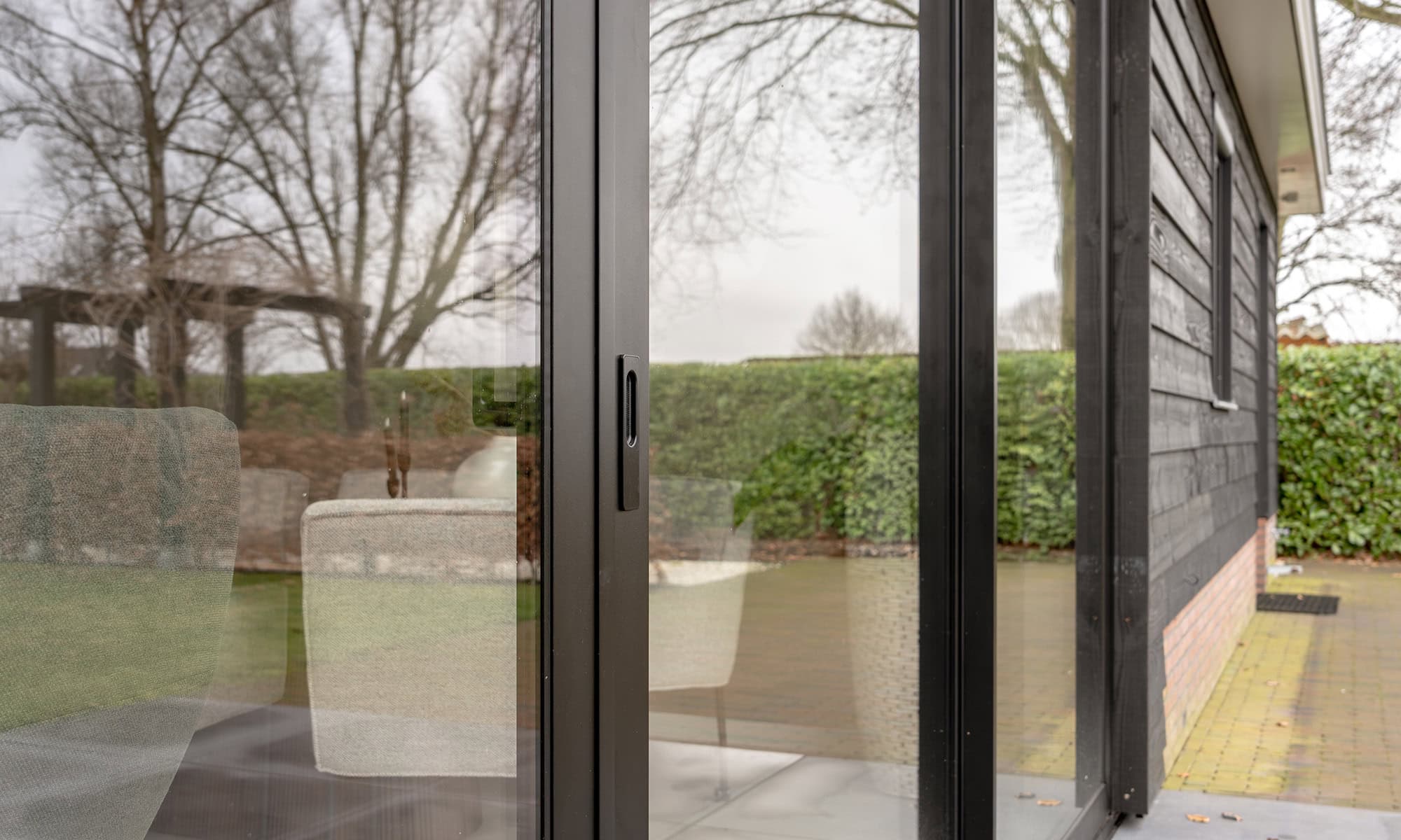Moderne glazen schuifdeur met zwarte omlijsting, perfect voor binnen- en buitengebruik, biedt een strakke uitstraling en veel natuurlijk licht.