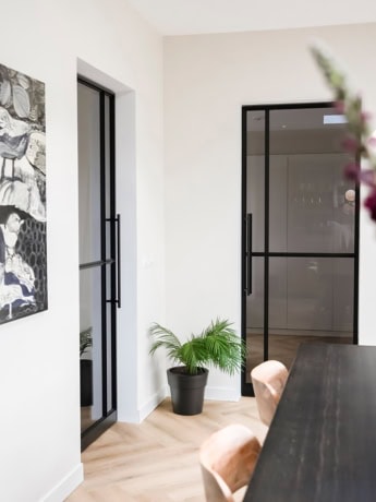 Modern steel door with black frame and glass, perfect for enclosing living spaces, custom-made by Aluwdoors.