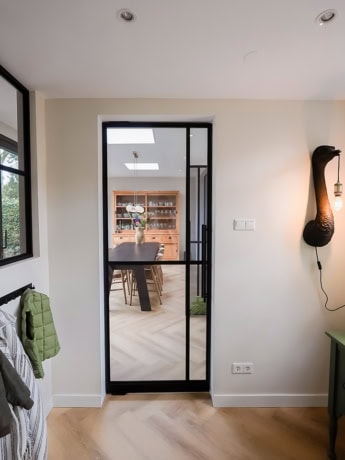 Moderne stalen deur met glazen panelen voor een industriële uitstraling.