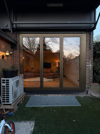 Moderne stalen schuifdeur met grote glazen panelen, perfect voor een stijlvolle en functionele toegang tot de tuin of patio, ontworpen door Aluwdoors voor maatwerk en kwaliteit.