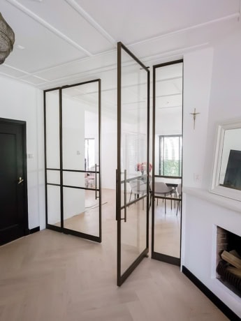 Aluwdoors stalen op maat gemaakte deur en wand met zwart frame in modern interieur.