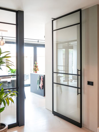 Robuuste stalen scheidingsdeur met glas op maat, modern design geschikt voor diverse interieurstijlen, geproduceerd door Aluwdoors.