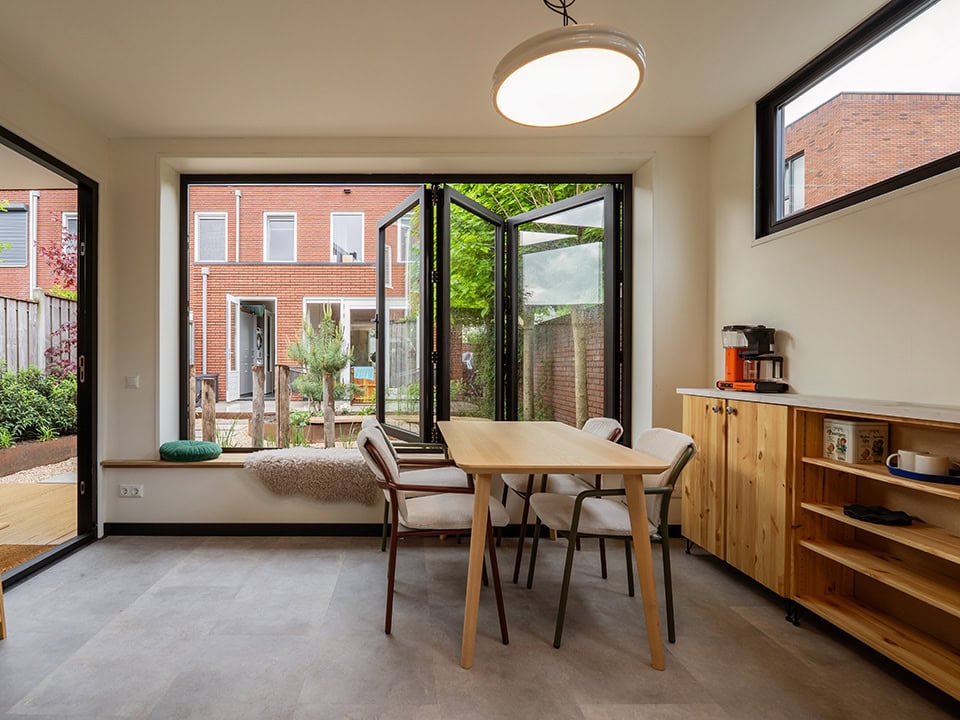 Moderne stalen tuindeur met grote ramen en openslaande deuren, perfect voor een lichte en open binnen- en buitenruimte, ontworpen door Aluwdoors voor maatwerk en kwaliteit.