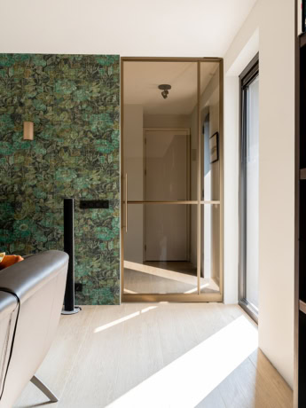 Glazen stalen schuifdeur met gouden frame in een modern interieur.