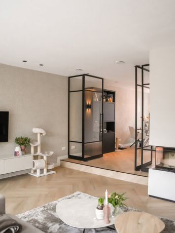 Modern steel partition with black metal frame and glass panels in a contemporary living space.