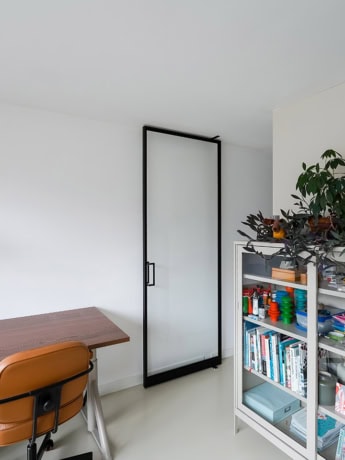 Glass steel sliding door with black frame in living room for a modern look.