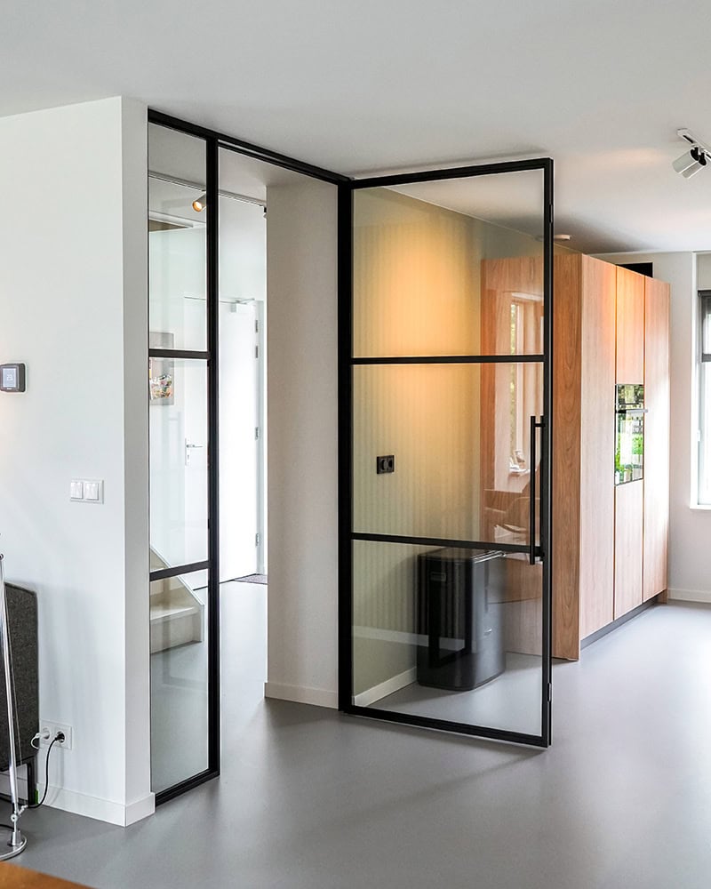 Hoogwaardige stalen scheidingswand met frame en gespiegelde schuifdeur in een modern interieur.