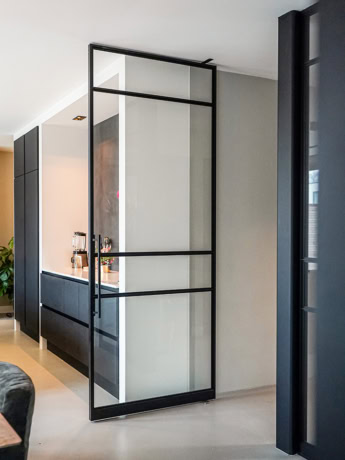 Modern steel door with glass panels, custom-made for a contemporary interior finish.