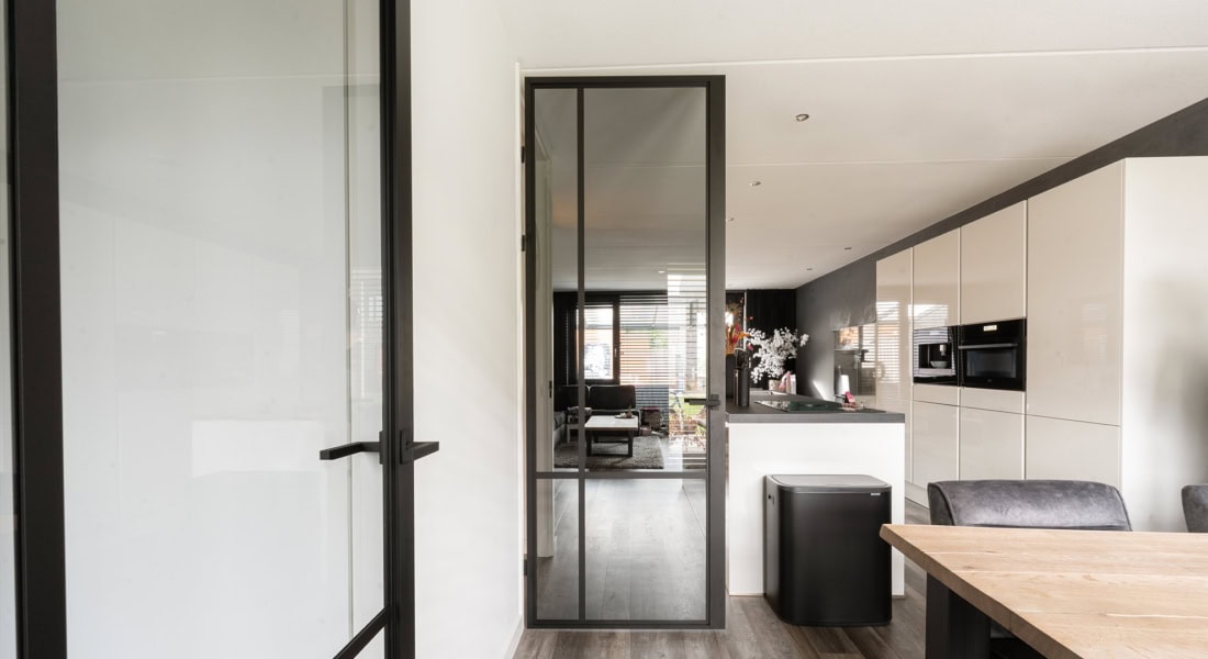 Modern stalen binnendeur met zwarte kader en glas, geschikt voor stijlvolle interieurs en maatwerk toepassingen in woningen en kantoren.