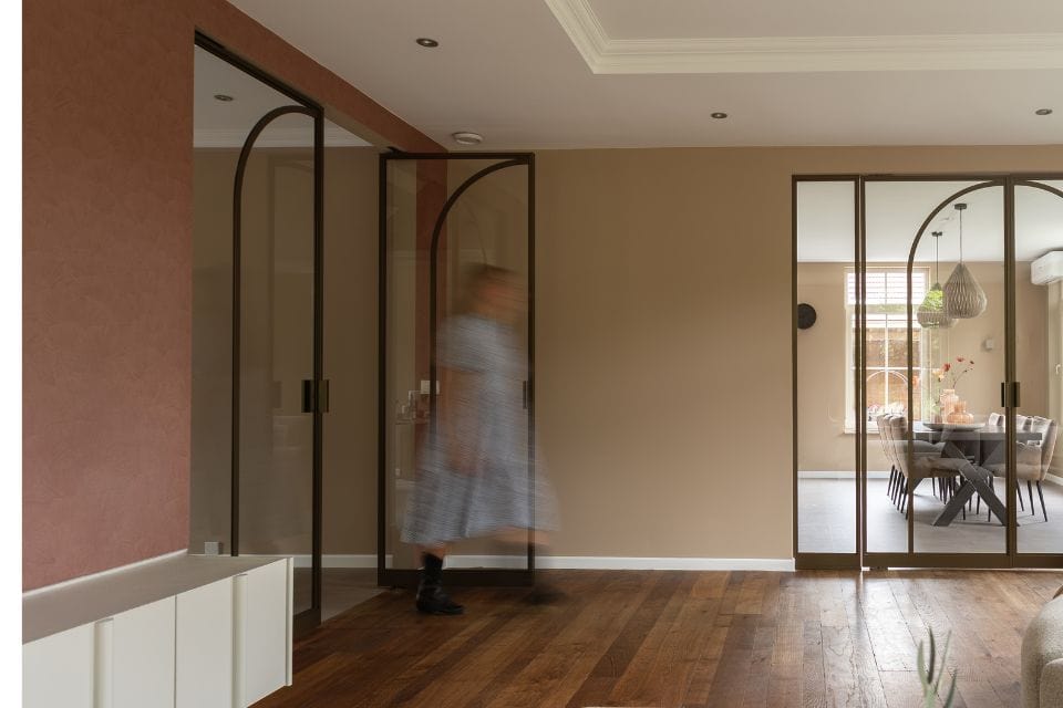 Elegant steel partition with modern glass doors in a bright living room.