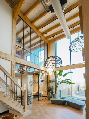 Modern custom-made steel doors and walls in an industrial living or working building with lots of natural light and wooden details.