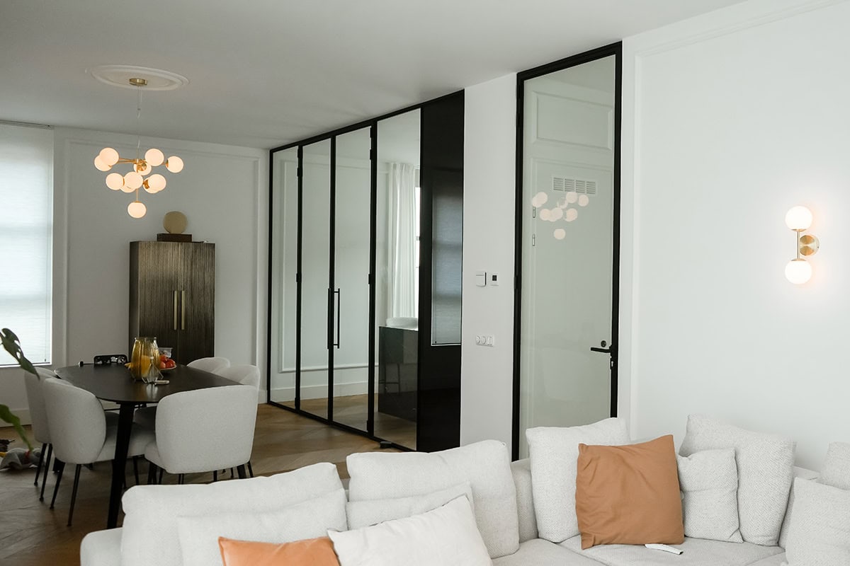 Moderne zwarte stalen binnendeuren en wanden in een minimalistisch wooninterieur.