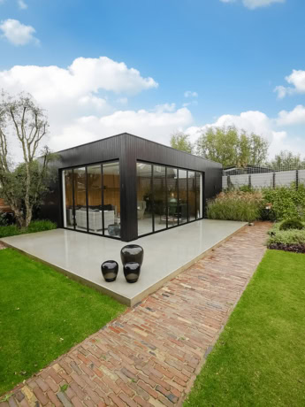 Elegant steel conservatory with custom-made walls and translucent sliding glass doors for a modern look.