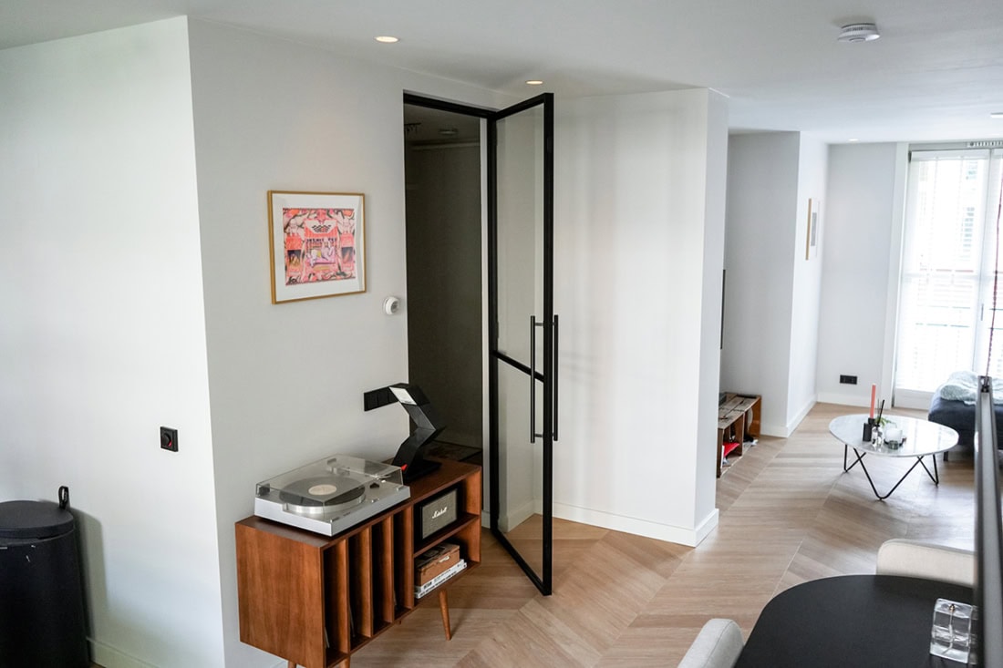 Moderne stalen terrasdeuren met zwart kader in een woning.