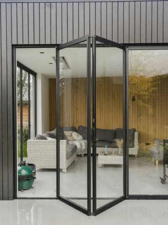 Retractable steel patio doors with glass panels for seamless indoor-outdoor connection.