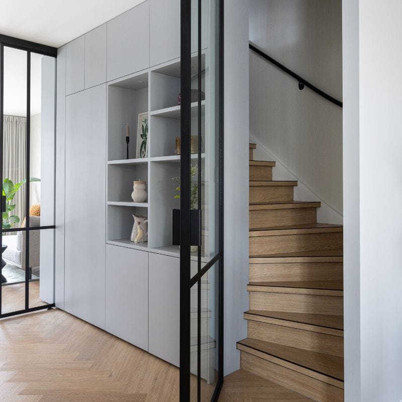 De hoekgreep op de scharnierdeur. De scharnierdeur sluit doormiddel van het kozijn, het trappenhuis goed af.