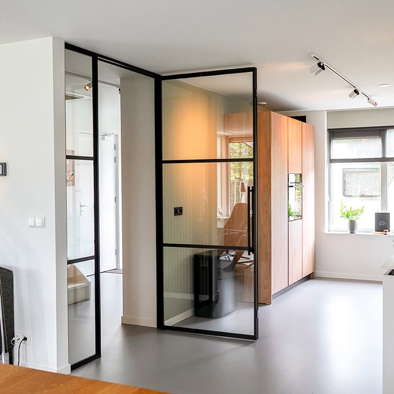 Stalen scharnierdeur met kozijn in de hal van Aluwdoors