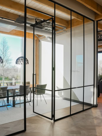 Sleek steel partition with glass panels in a modern office space.