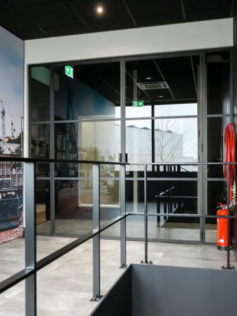 Aluwdoors steel partition with glass doors in a modern office design.