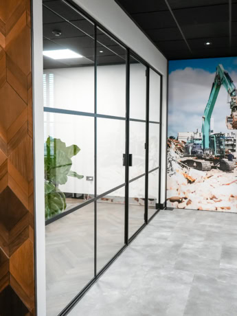 Large glass steel partition with black metal frame in a modern office space.