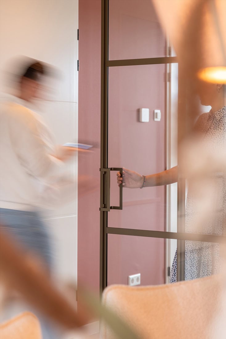 Moderne stalen scheidingswand en deur in een interieur, op maat gemaakt door Aluwdoors.