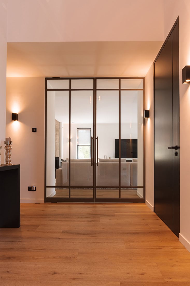 Hoge kwaliteit stalen glasdeur met strakke zwarte omlijsting voor moderne interieurs.