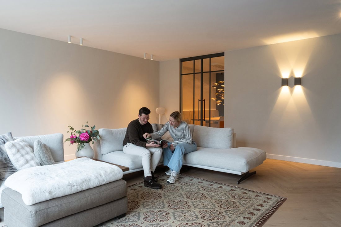 Strakke witte industriële stalen deur met glas-in-loodpanelen en zwarte frame, geschikt voor moderne scheidingswanden.