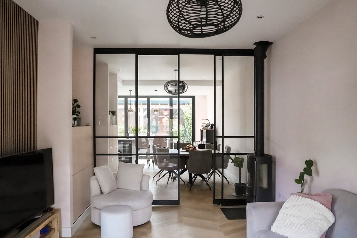 Strakke zwarte stalen binnendeur en wandafwerking in een modern wooninterieur, flexibel en stijlvol scheidingswand voor een eigentijdse uitstraling.