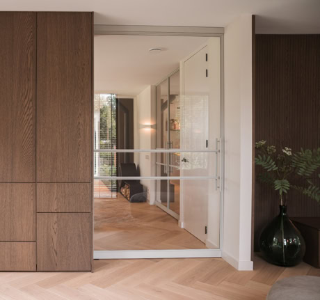 Modern stalen schuifdeur met glazen panelen in een eigentijds interieur.