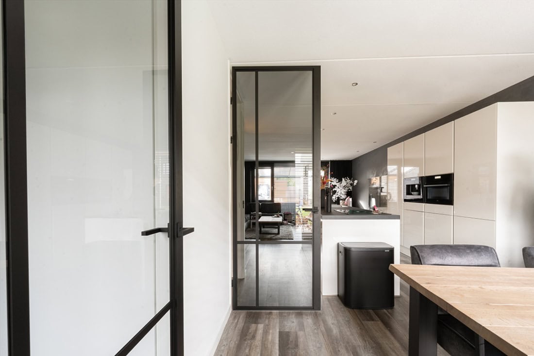 Modern stalen tuindeur met zwart frame, geschikt voor binnen- en buitengebruik, op maat gemaakt door Aluwdoors.