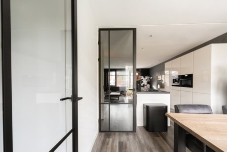 Modern stalen tuindeur met zwart frame, geschikt voor binnen- en buitengebruik, op maat gemaakt door Aluwdoors.