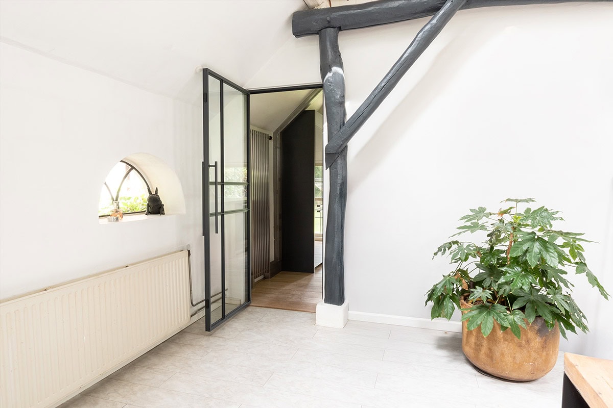 Moderne stalen scheidingsdeur met glazen panelen in zwart frame.