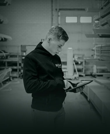 Hulp in de werkplaats van Aluwdoors met stalen deuren en wanden op maat, focus op vakmanschap en maatwerk.